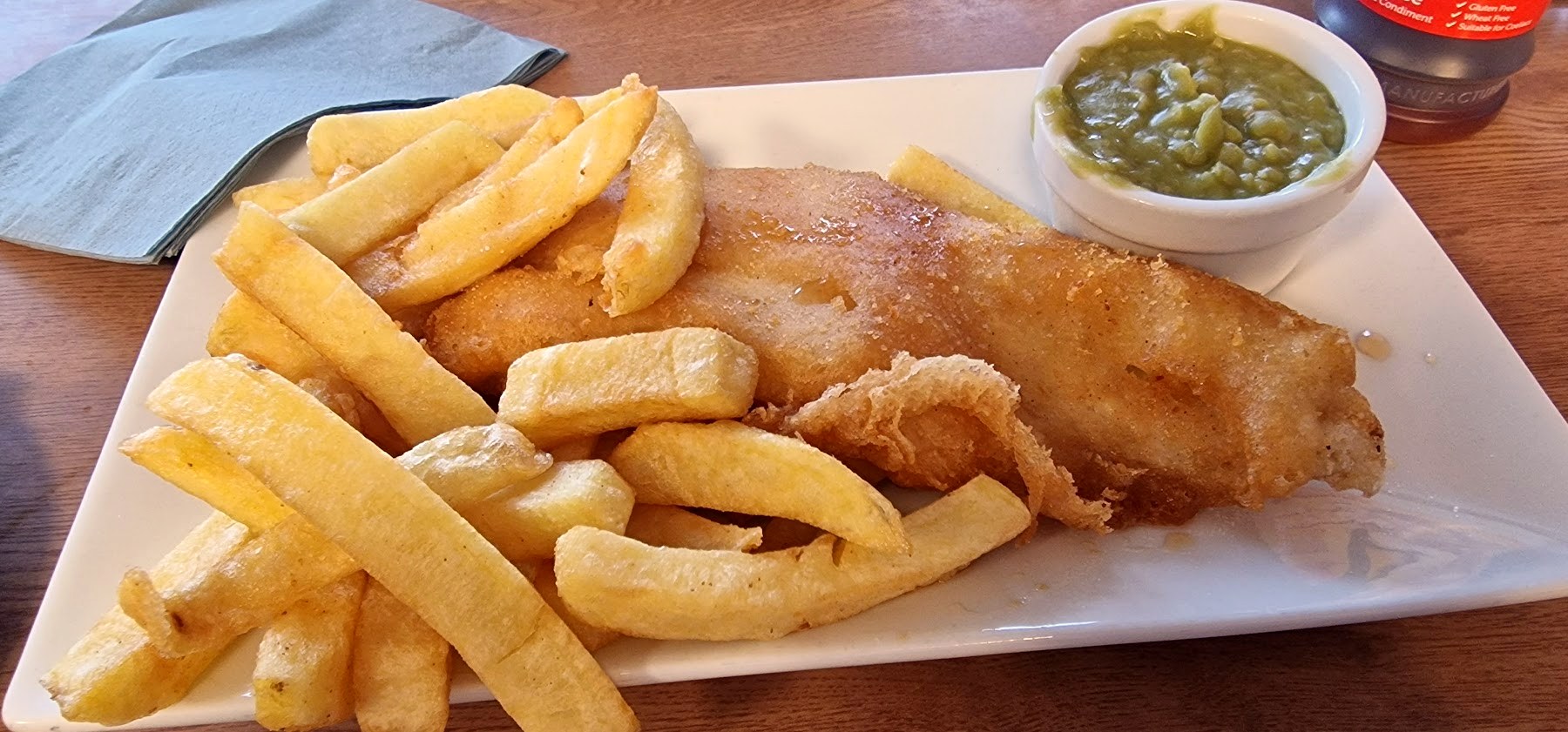 Fish and chips served on a wooden table